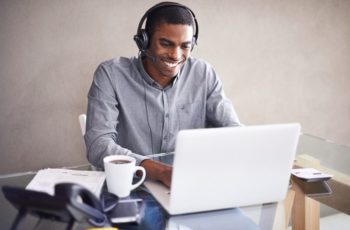 homem utilizando headset redragon enquanto usa o notebook