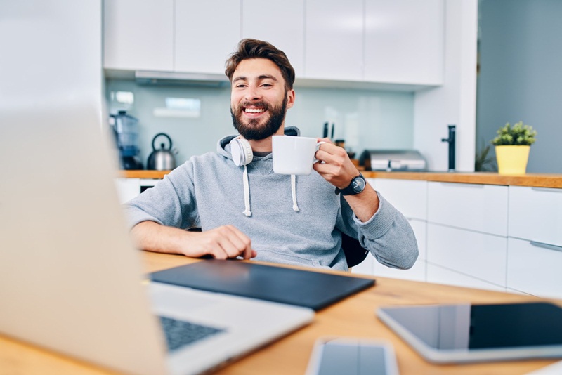 homem jovem tomando uma xícara de cafe no home office