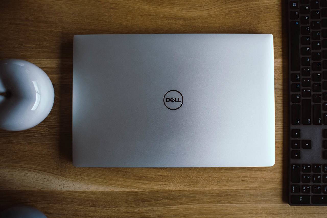 Notebook Dell com tela fechada ao lado de periféricos