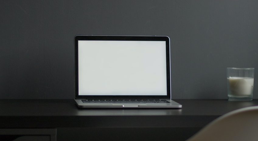 Notebook com tela branca sobre mesa