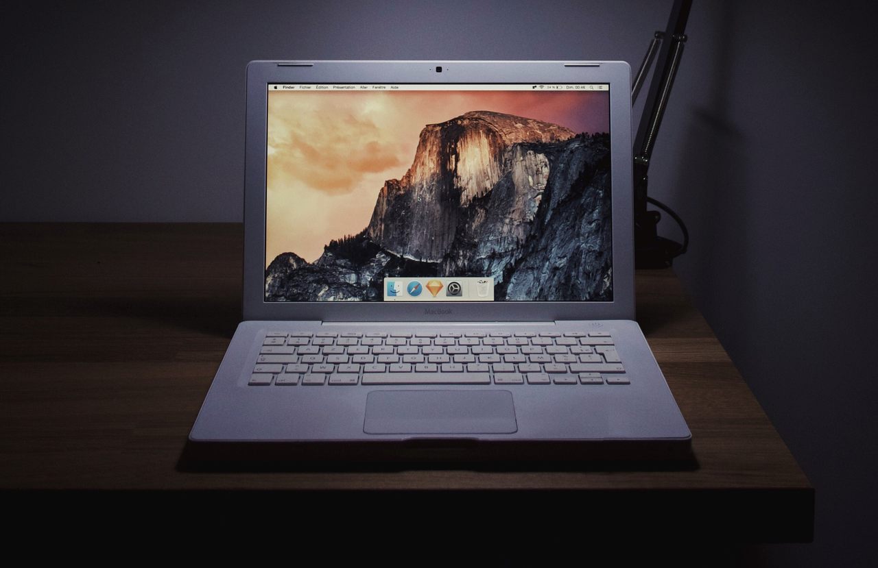 Notebook Mac com tela de fundo personalizada sobre mesa