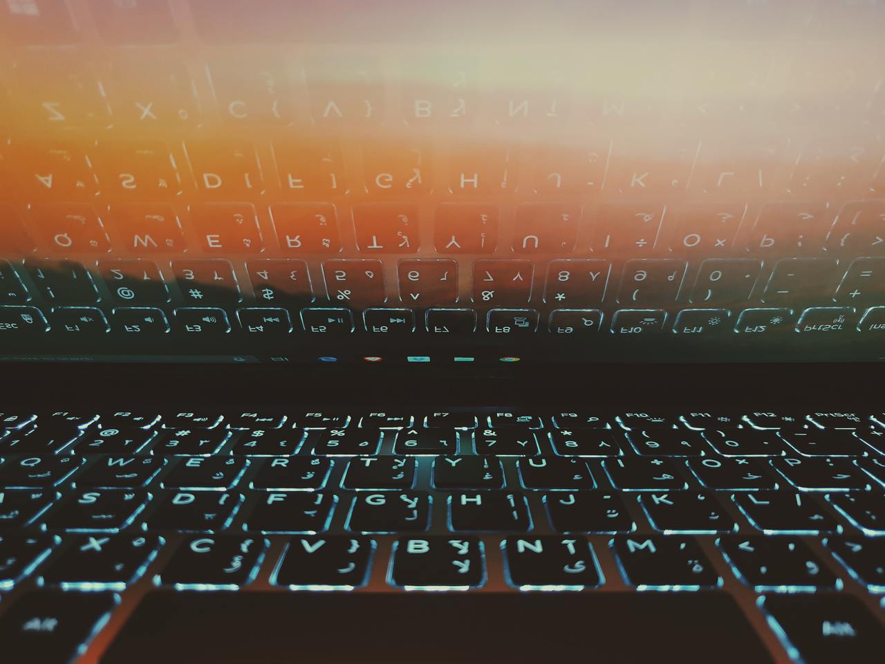 notebook com teclado iluminado refletindo em tela
