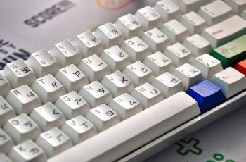 teclado branco gamer com algumas teclas coloridas