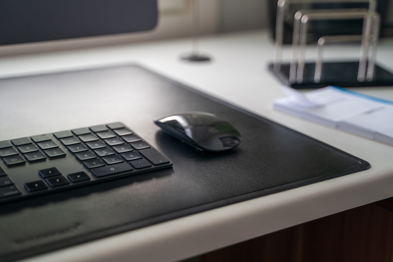 teclado e mouse wireless sobre capa de borracha em cima de mesa