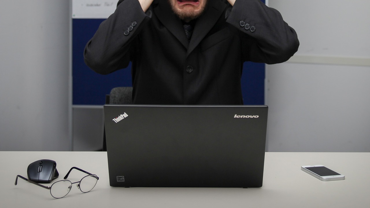 Homem desesperado com a mão na cabeça porque tela notebook fica piscando
