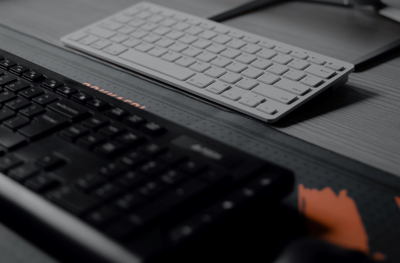 Dois tipos de teclado diferentes sobre uma mesa cinza