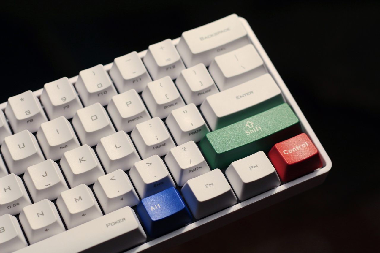 Teclado branco gamer com peças coloridas sobre fundo preto