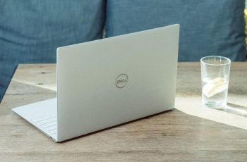 Notebook dell sobre uma mesa ao lado de um copo com água