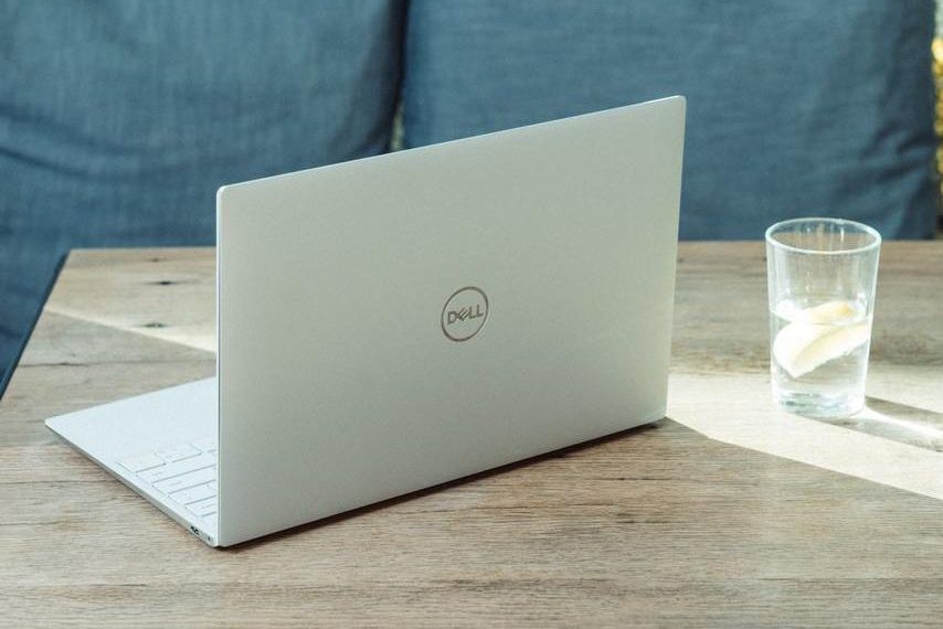 Notebook dell sobre uma mesa ao lado de um copo com água