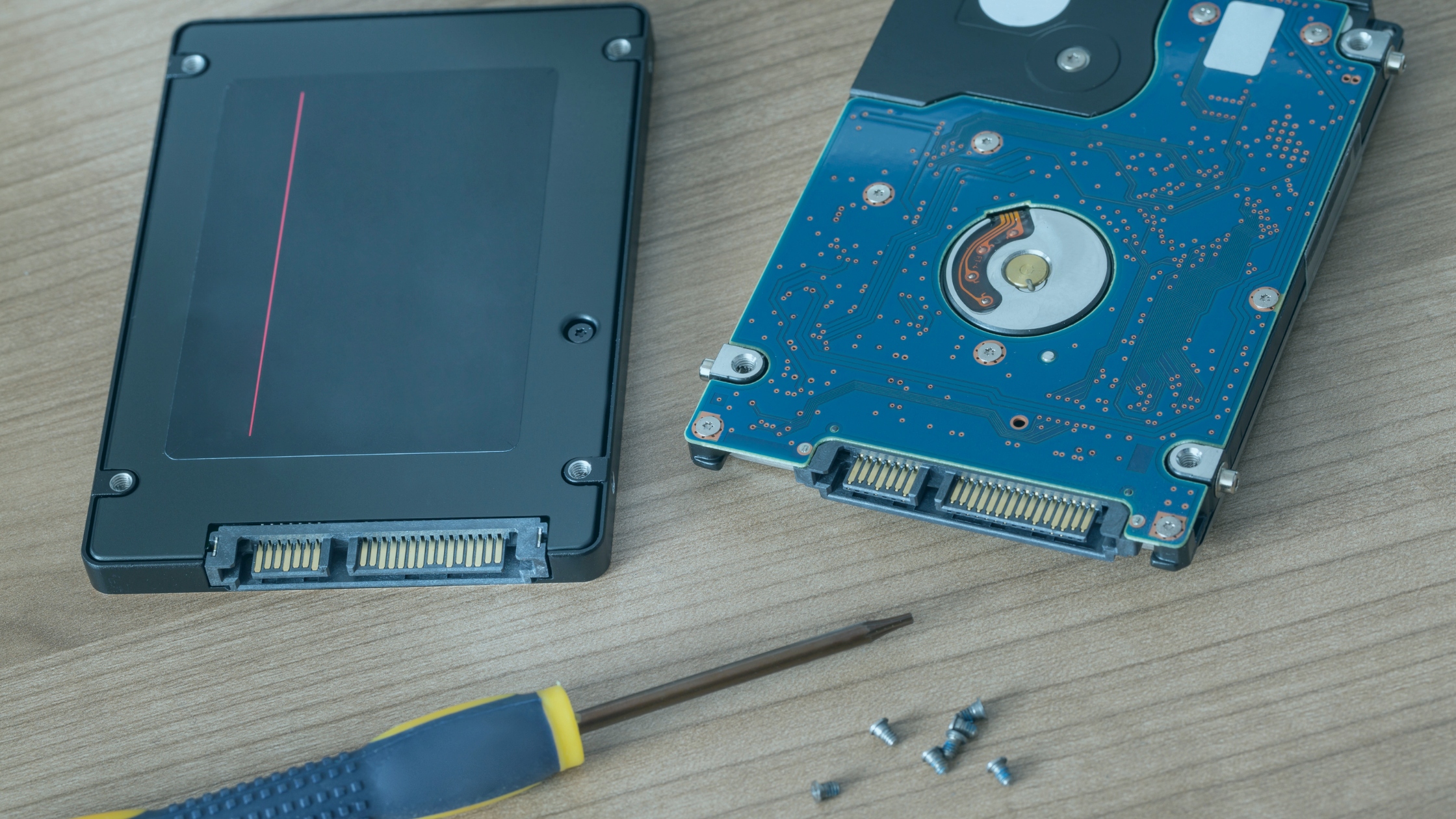 Dois SSDs em uma mesa, com uma chave e alguns parafusos
