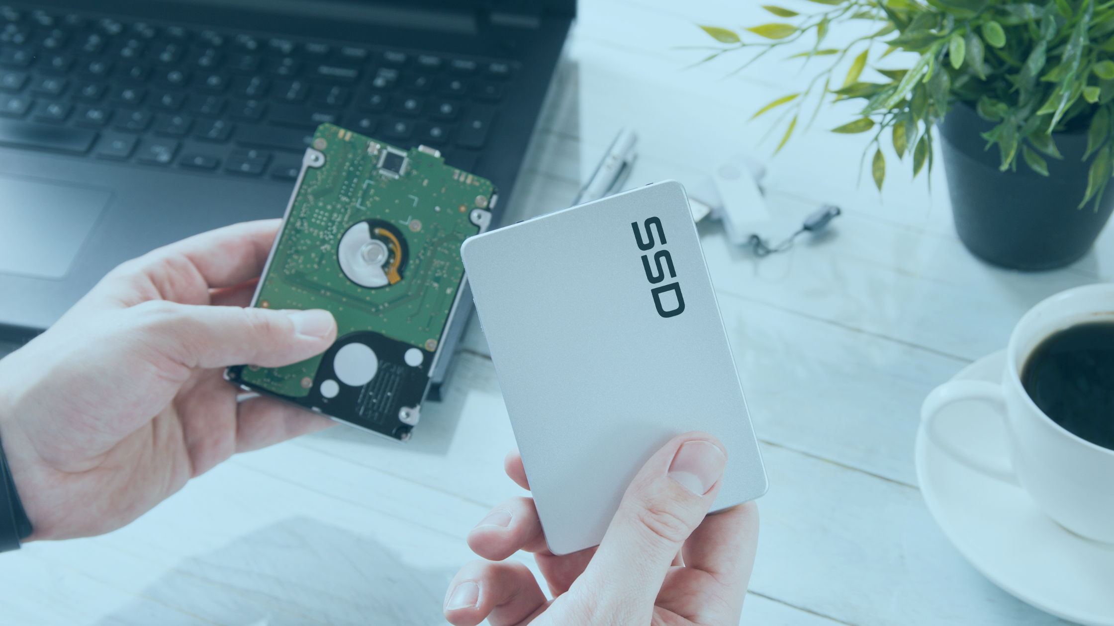 Mão segurando um cartão SSD com notebook ao lado