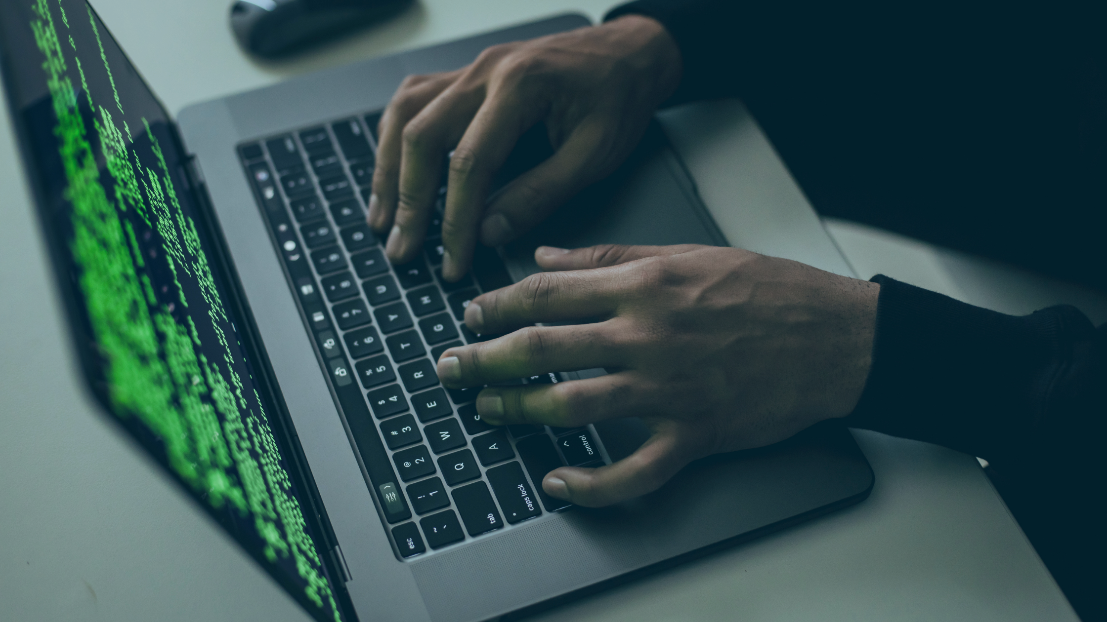 Pessoa usando um notebook, na tela uma sequência numérica indica que o notebook está com vírus